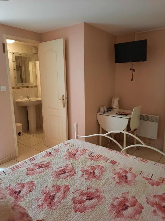 a bedroom with a bed and a bathroom with a sink at CHAMBRE LEUCATE VILLAGE in Leucate