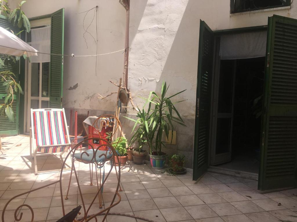a patio with chairs and plants and an open door at Green house in Naples