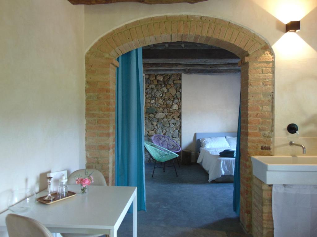 een kamer met een bed, een tafel en een wastafel bij Montalcinello Casavolta WIFI, aria condizionata in Montingegnoli