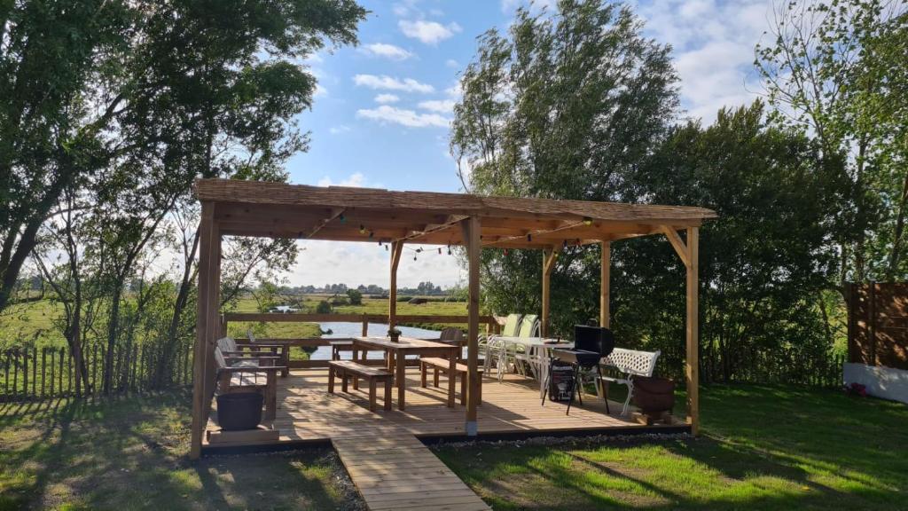 cenador de madera con mesa y sillas en La Maison des Marais de Sallertaine, en Sallertaine