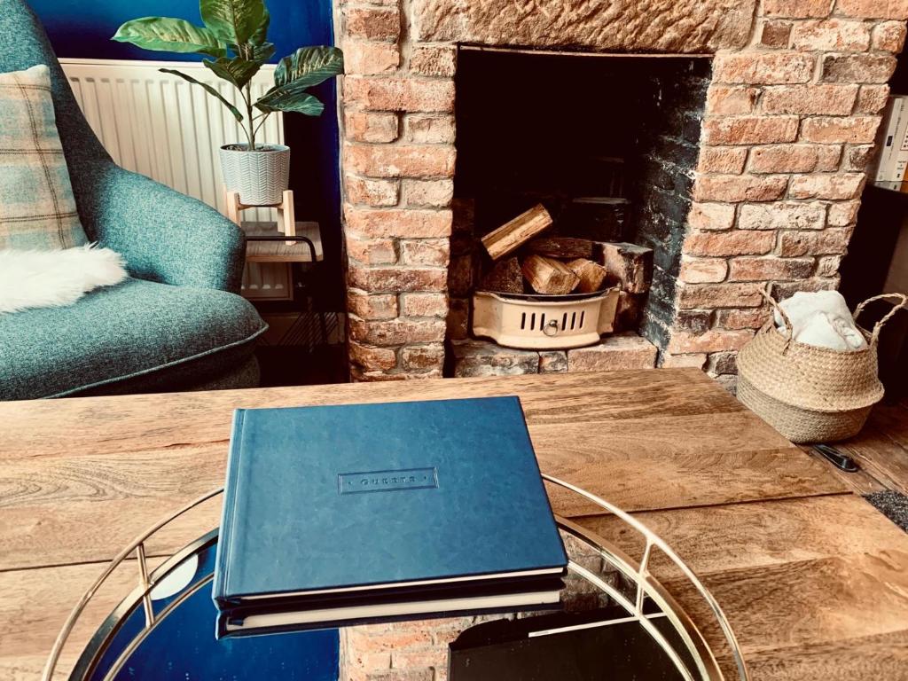 un ordenador portátil sentado en una mesa frente a una chimenea en The Tenth House, Grade II Listed Georgian Town House, Wirksworth, Derbyshire, Peak District Cottage, Sleeps 4, en Wirksworth