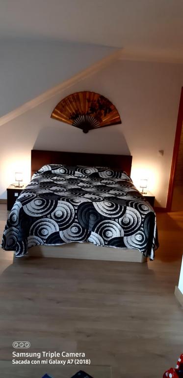 um quarto com uma cama com um cobertor preto e branco em Tomillaron House em Las Rozas de Madrid