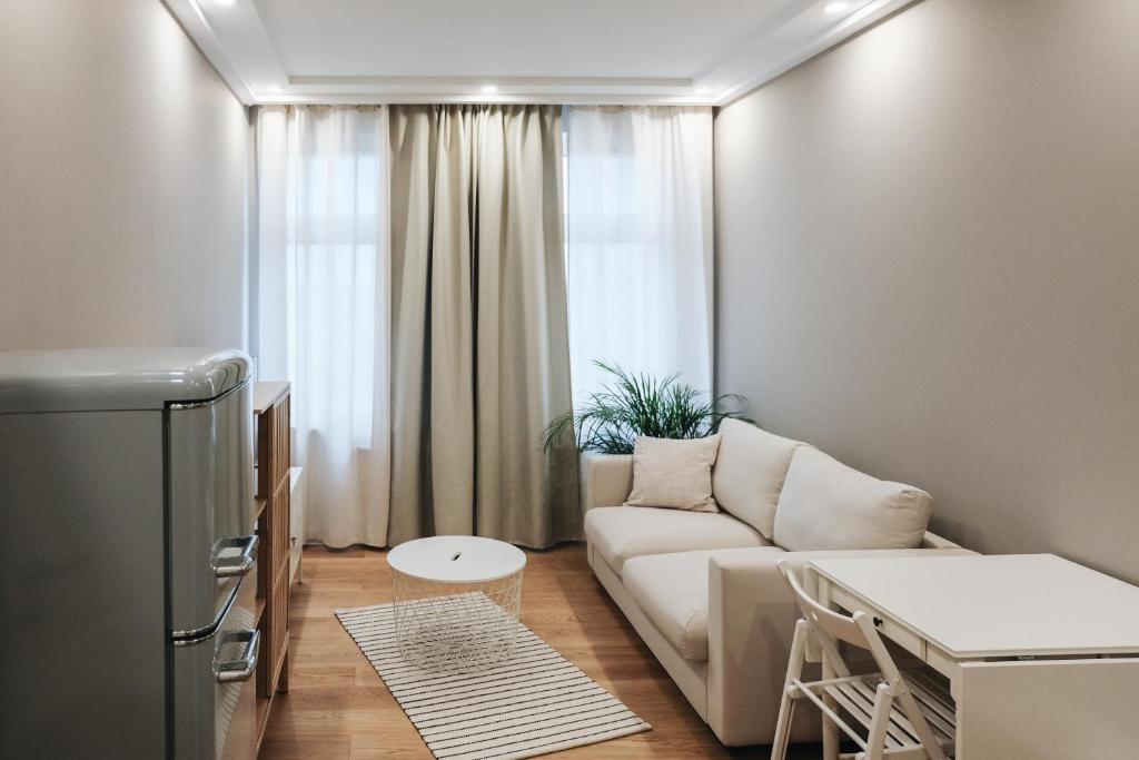 een woonkamer met een bank en een tafel bij Prorsus Apartment Design in Leipzig