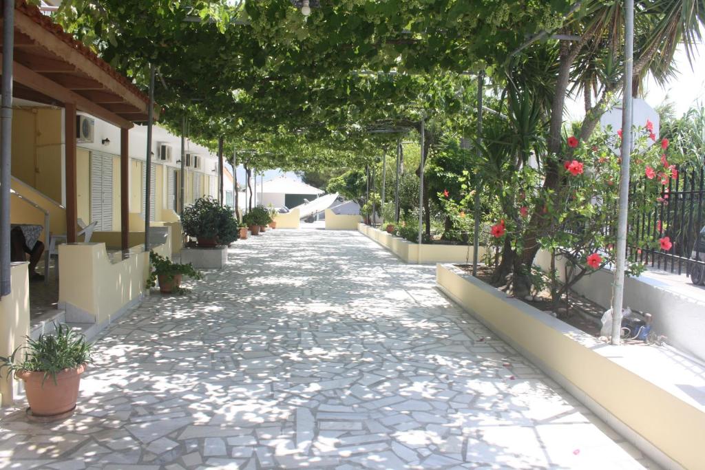 a cobblestone street with trees and plants on it at MARIA STUDIOS LAGANAS in Laganas