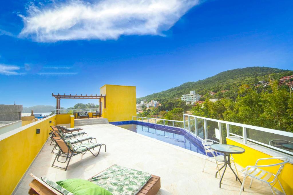 un balcón con sillas y una piscina en un edificio en Pousada Vila Portuguesa, en Bombinhas