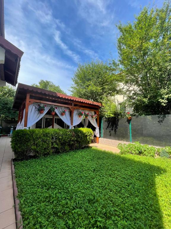 a pavilion with a lawn in front of a building at Casa Atlas in Eforie Sud