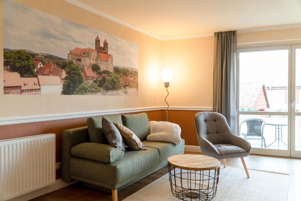 ein Wohnzimmer mit einem Sofa und einem Stuhl in der Unterkunft Ferienresidenz Schlossblick in Quedlinburg