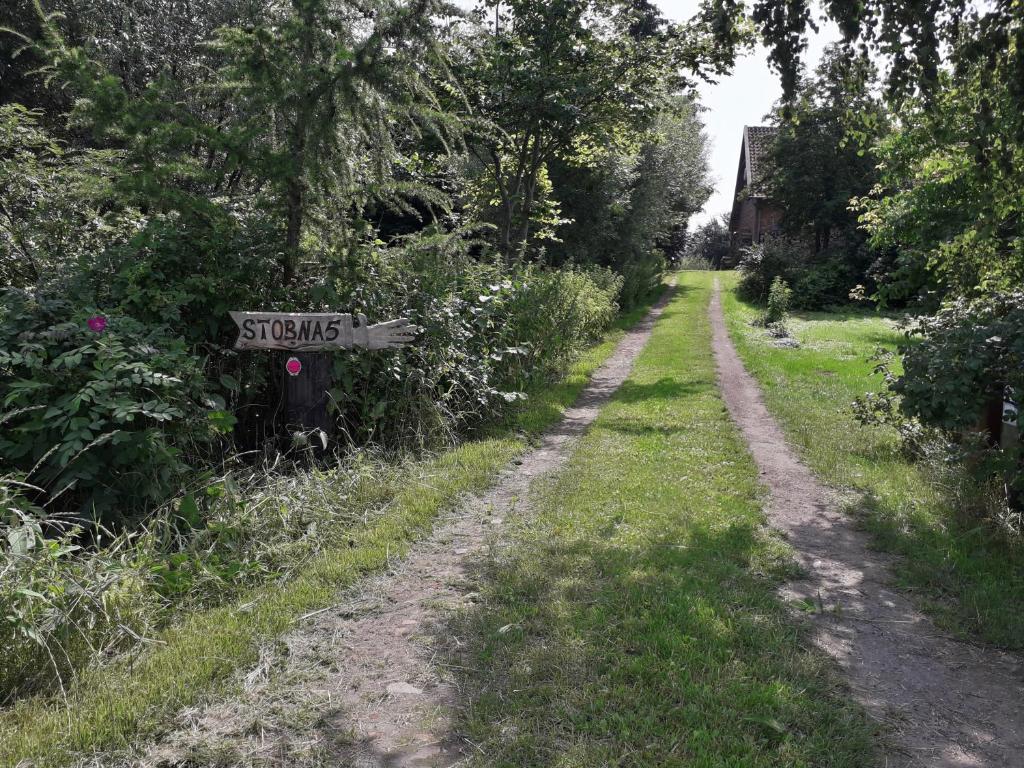 un chemin de terre avec un panneau indiquant des échasses dans l'établissement Mała Baza Stobna 5, à Nowy Dwór Gdański