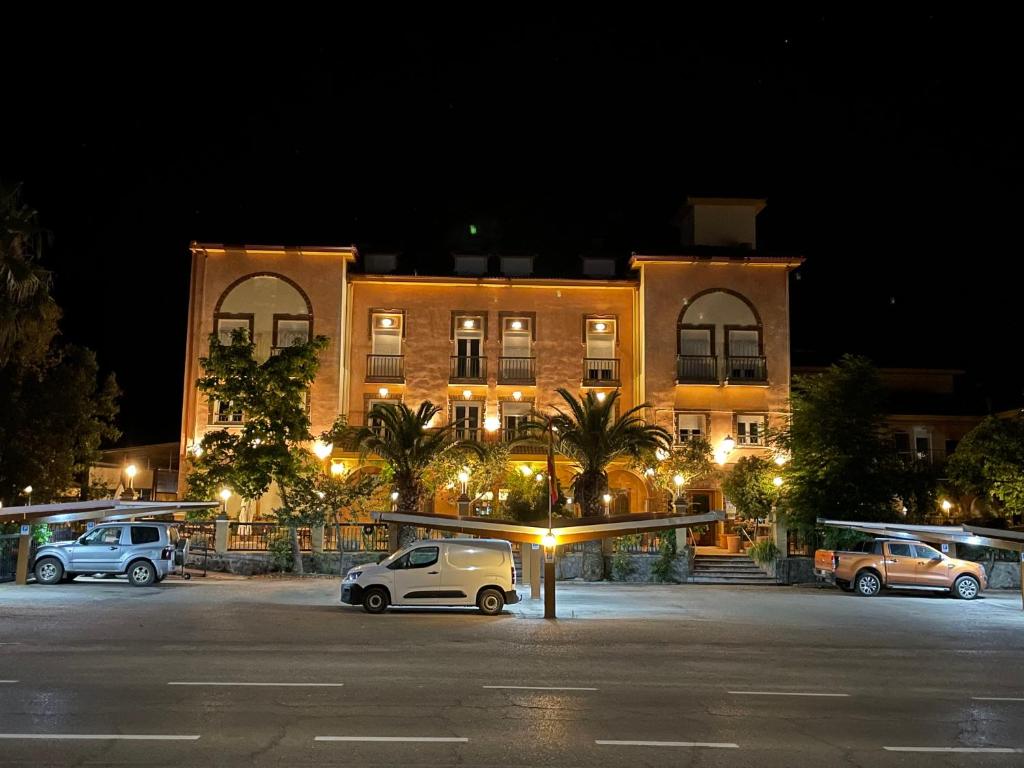 un edificio con coches estacionados en un estacionamiento por la noche en Hotel Rural Sierra De Segura, en Puente de Génave