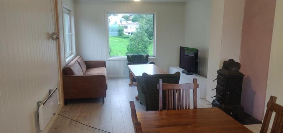 uma sala de estar com uma mesa e uma televisão em House on the lake em Bogen
