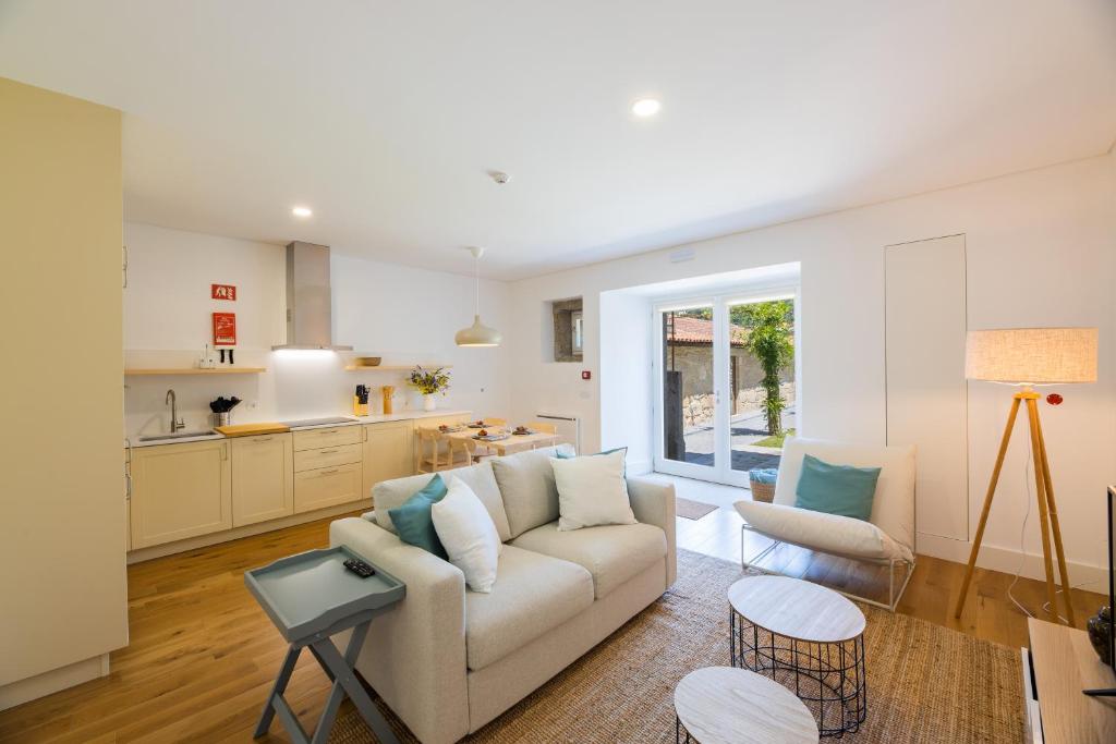 a living room with a couch and a kitchen at Linden Tree House A and B in Caldelas