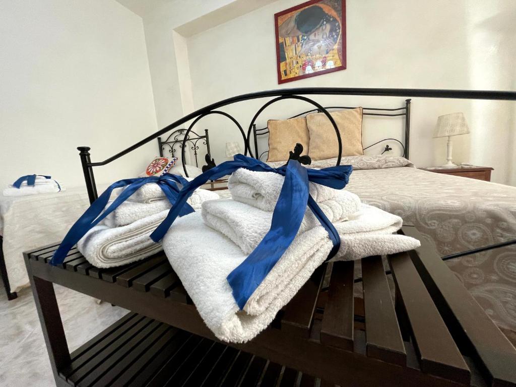 a bedroom with a bed with towels and blue bows at Le lumie in Pachino