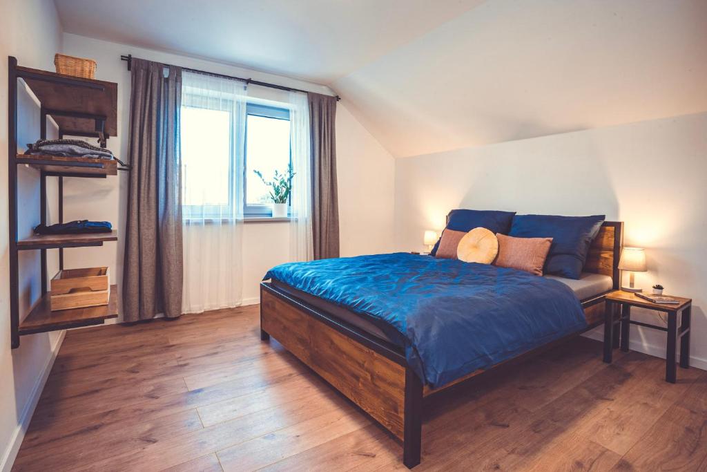 um quarto com uma cama com lençóis azuis e uma janela em Apartmány pod Suchým vrchem em Stachy