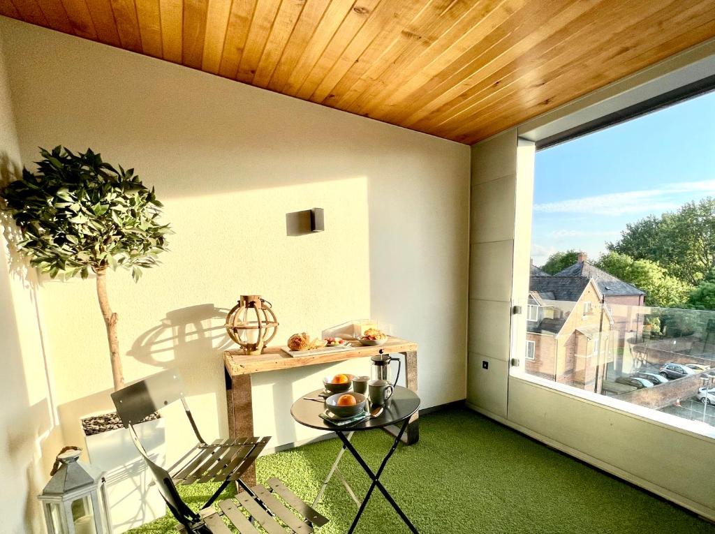 a balcony with a table and a large window at Apartment Twelve in Shrewsbury