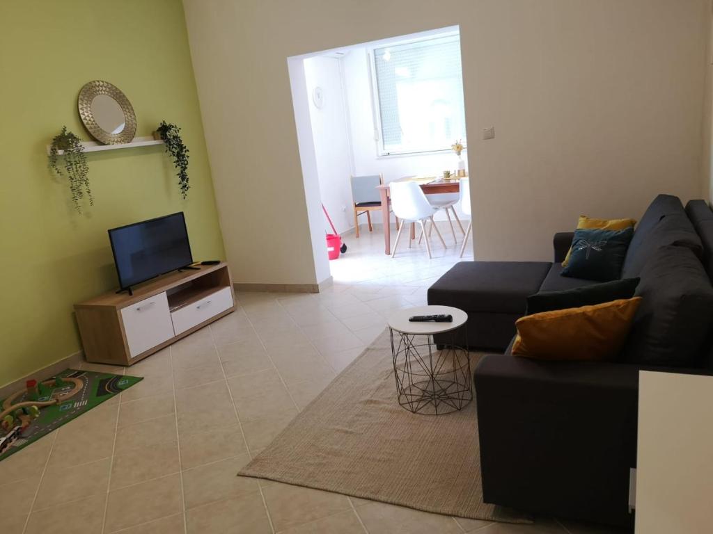 a living room with a couch and a tv at Apartmani Ljuba in Rogoznica