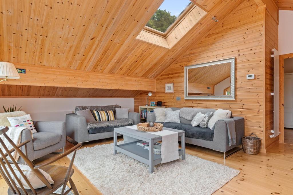 een woonkamer met twee banken en een tafel bij Lodge 5 Longbury - Luxury Lodge, Golf Course Views, Restaurant and Spa Facilites in Penally