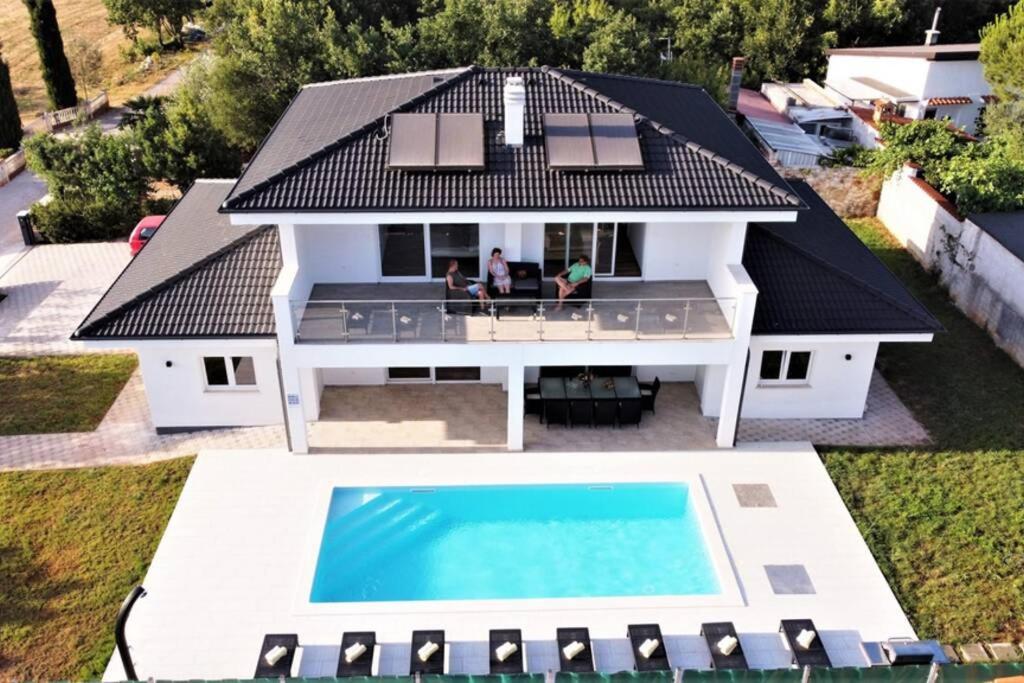 an aerial view of a house with a swimming pool at New Villa with Pool in Barbariga