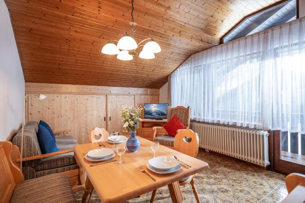 a room with a table and chairs and a television at Ferienwohnanlage Oberaudorf F7 mit Hallenbad und Sauna in Oberaudorf