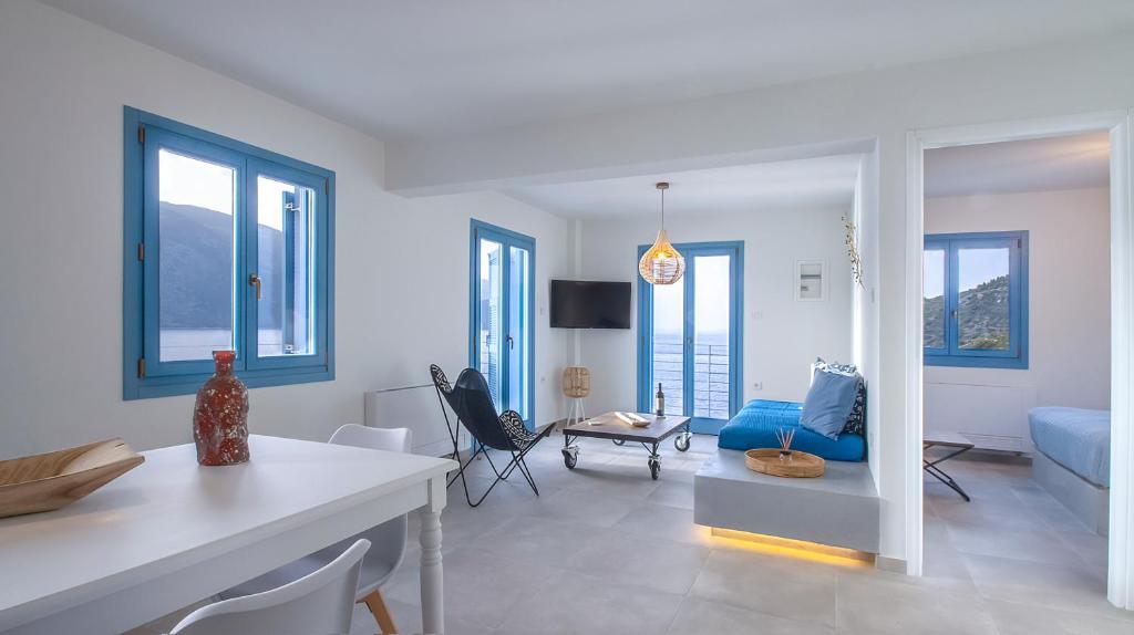 a living room with white walls and a blue couch at Akasha Suite III in Vathi