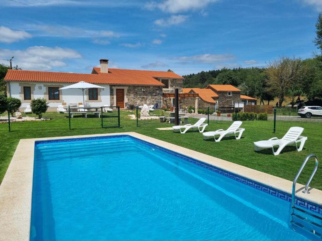 une villa avec une piscine et une maison dans l'établissement Pensión Ribadiso, à Arzúa