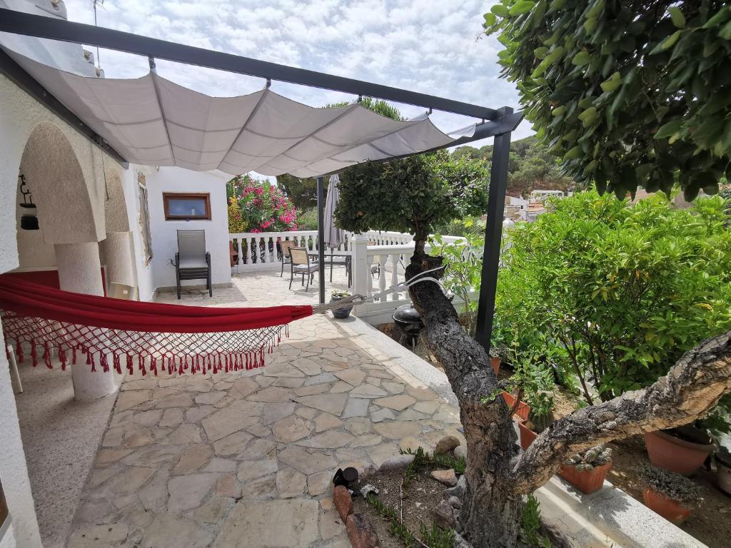 a patio with a hammock under a white umbrella at Casa Morisca in Tossa de Mar