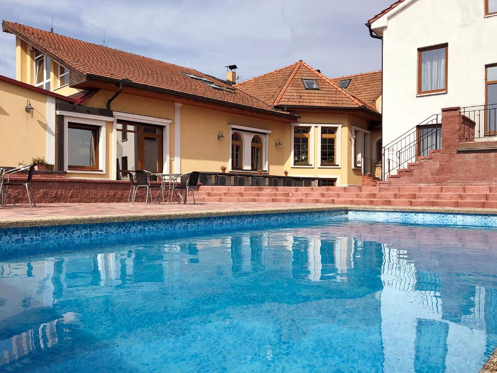 a swimming pool in front of a house at Penzion SURF in Blansko