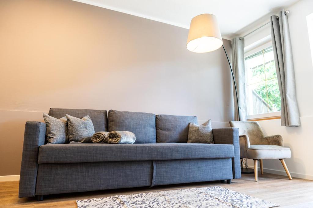 um sofá azul numa sala de estar com um candeeiro em Flow Apartments Margareta em Parcines