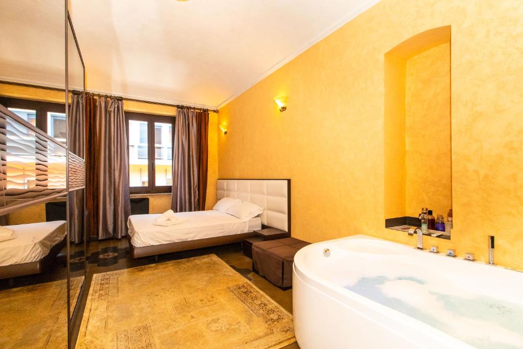łazienka z wanną i sypialnia z łóżkiem w obiekcie Borgo San Paolo Stylish Apt with Jacuzzi w Turynie