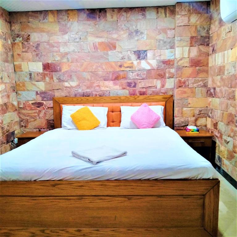 Un dormitorio con una cama con almohadas de colores. en Hotel Vista Inn DHA, en Rawalpindi