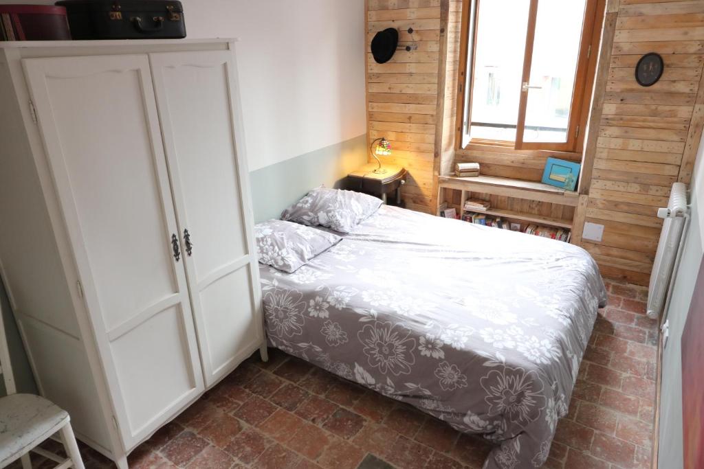 um pequeno quarto com uma cama e uma janela em Maison du Lys en Layon em Les Cerqueux-sous-Passavant