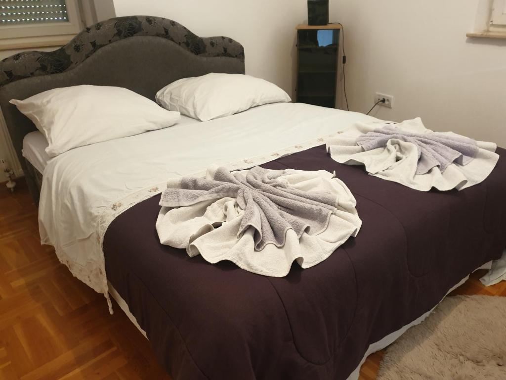 Una cama con manta y almohadas. en Vaikiki Apartman LM, en Novi Pazar