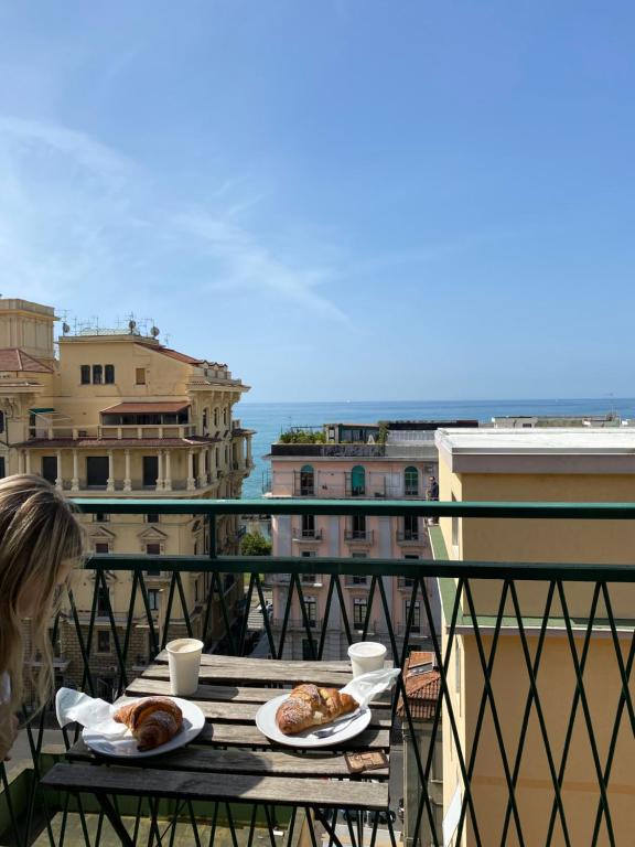 stół z dwoma talerzami jedzenia na balkonie w obiekcie Marchesa Lulu w mieście Salerno