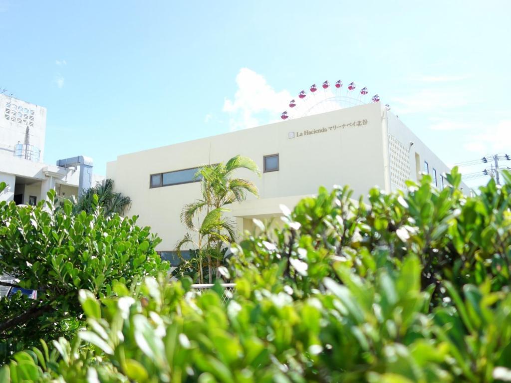 a white building with trees in front of it at サンライン北谷コンドミニアムリゾート in Chatan