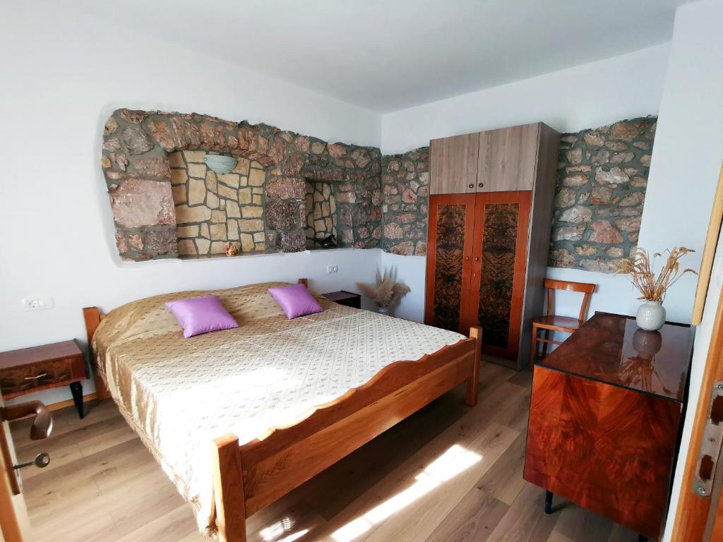 a bedroom with a bed with purple pillows on it at Villa Mira Garica in Garica