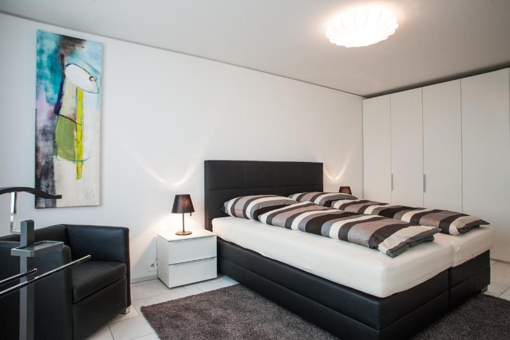 Cham的住宿－CITY STAY - Zugerstrasse，一间卧室配有一张大床和黑色床头板