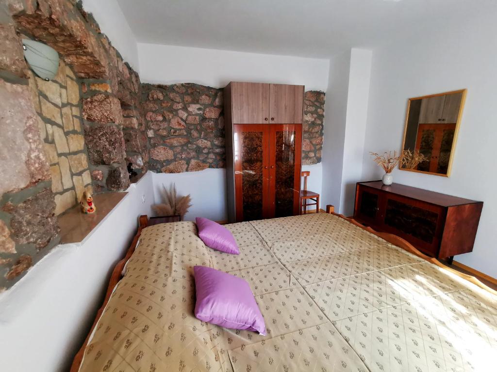 sypialnia z dużym łóżkiem z fioletowymi poduszkami w obiekcie Villa Mira Garica by El-Pi Tours w mieście Garica