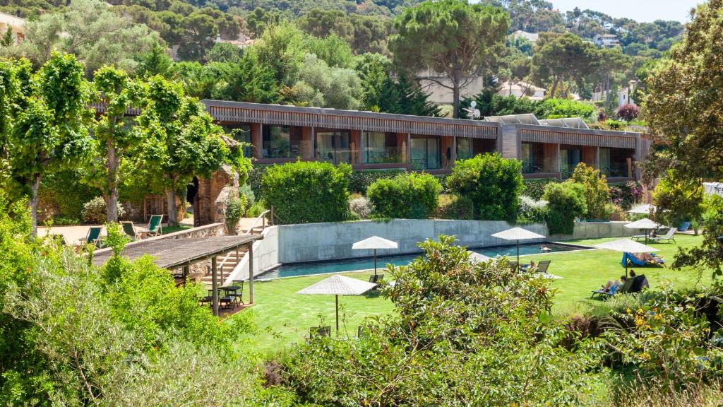 a building with a garden in front of it at Hotel Mas Pastora - Adults Only in Llafranc