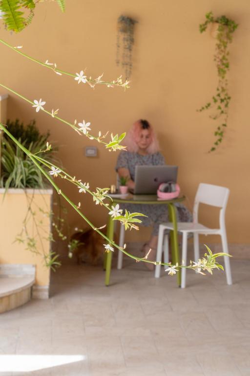 a man sitting at a table with a laptop computer at Gu Hotel in Guidonia