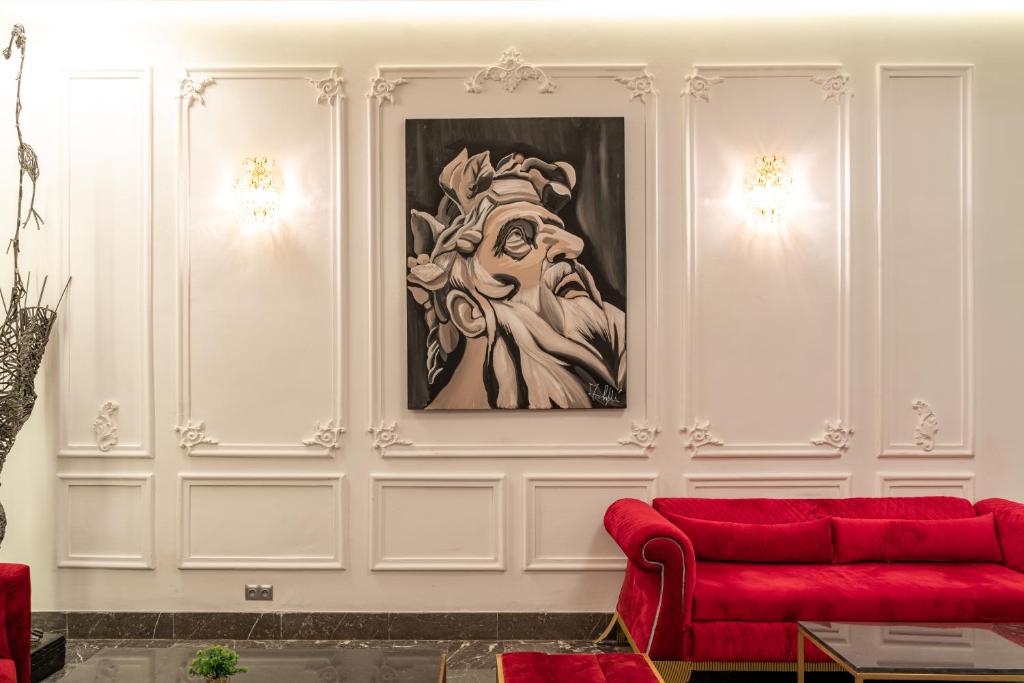 a living room with a red couch and a painting at Hotel Majestic in Casablanca