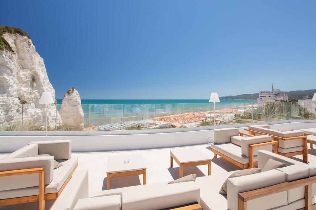 a living room with white furniture and a view of the ocean at Hotel Falcone in Vieste