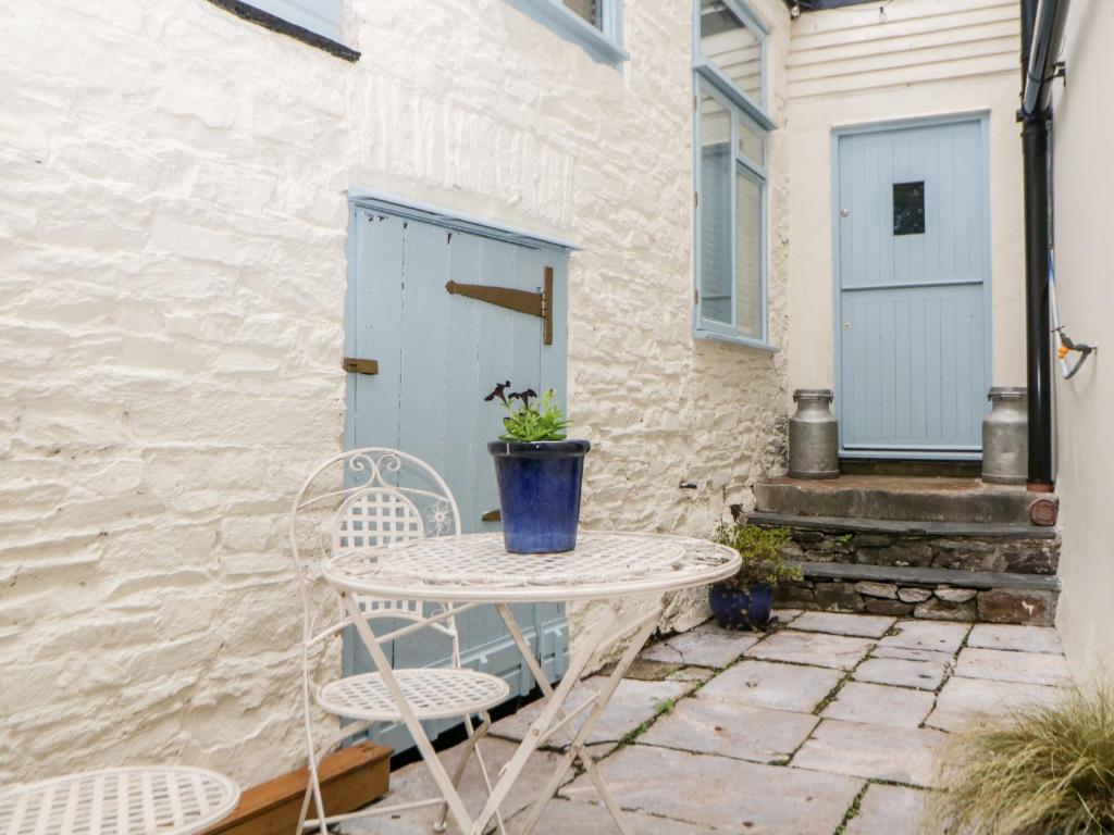 a table and two chairs on a patio with a door at The Old Dairy in Torpoint