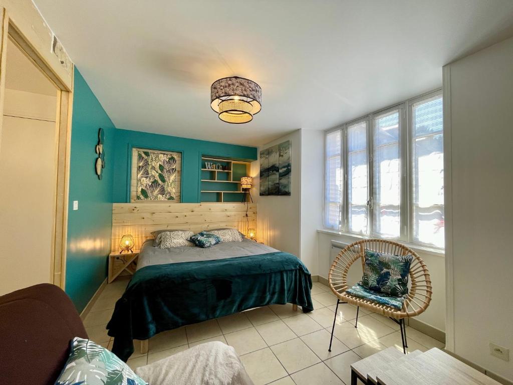 una camera da letto con pareti blu e un letto e una sedia di Le Bohème a Bayeux