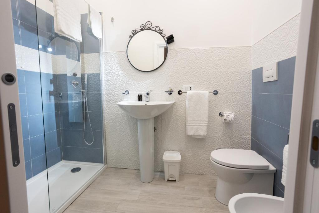 un bagno con lavandino, water e specchio di EXCLUSIVE ROOMS Al Vicoletto a Scalea