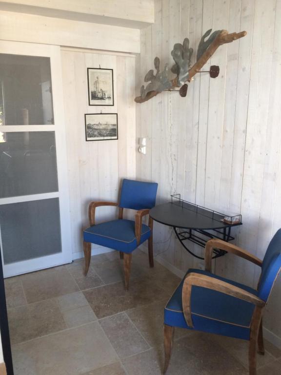 une chambre avec deux chaises, une table et une fenêtre dans l'établissement La Galerie, à La Chaume