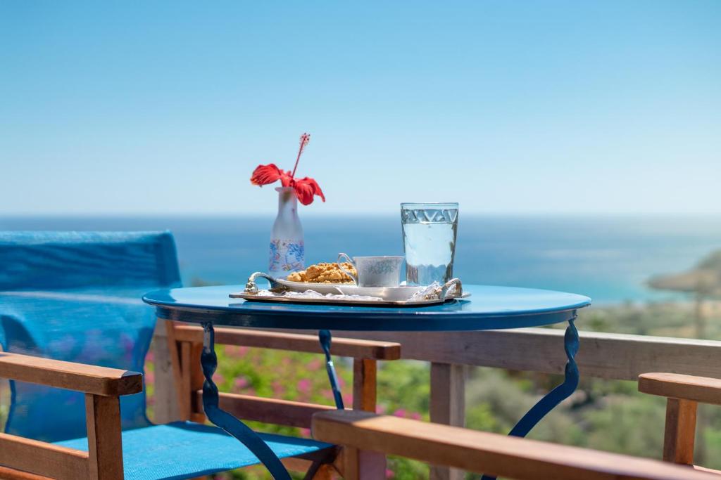 a table with a plate of food and a drink at Anthia Apartment Sea View in Káto Zákros