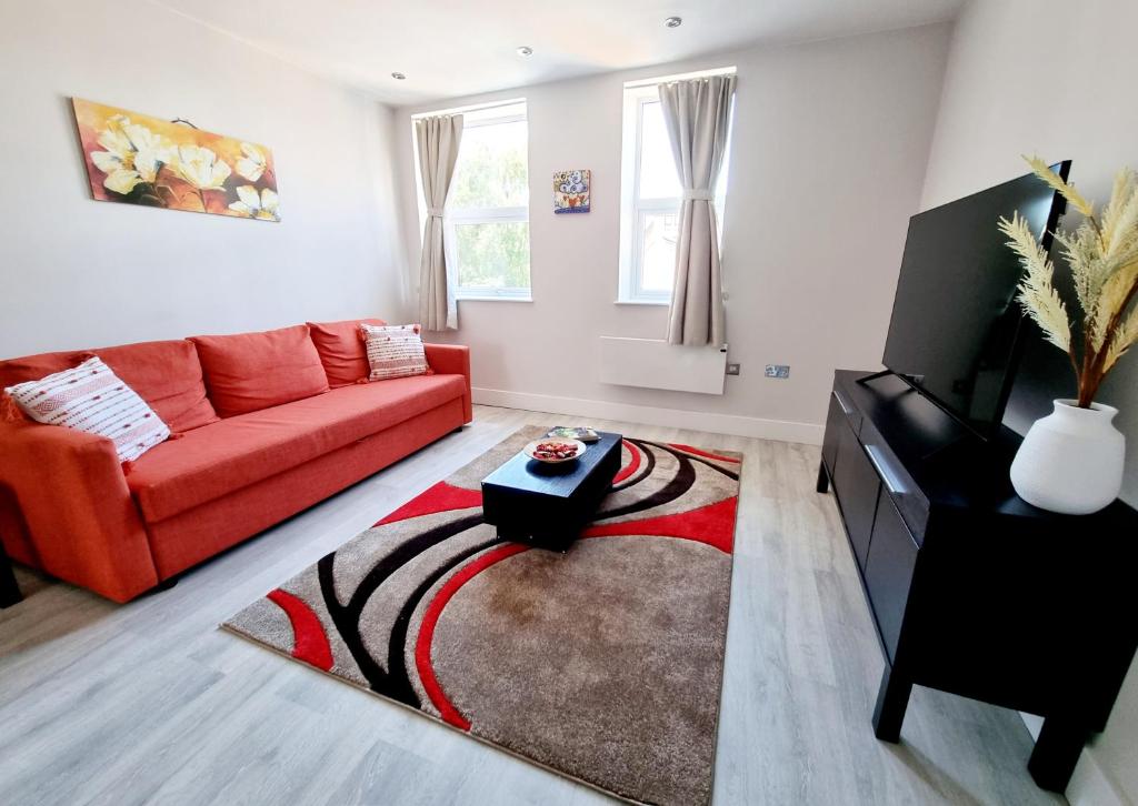 a living room with a red couch and a rug at Modern Maisonette 2 Bedrooms Newly Renovated in Bournemouth