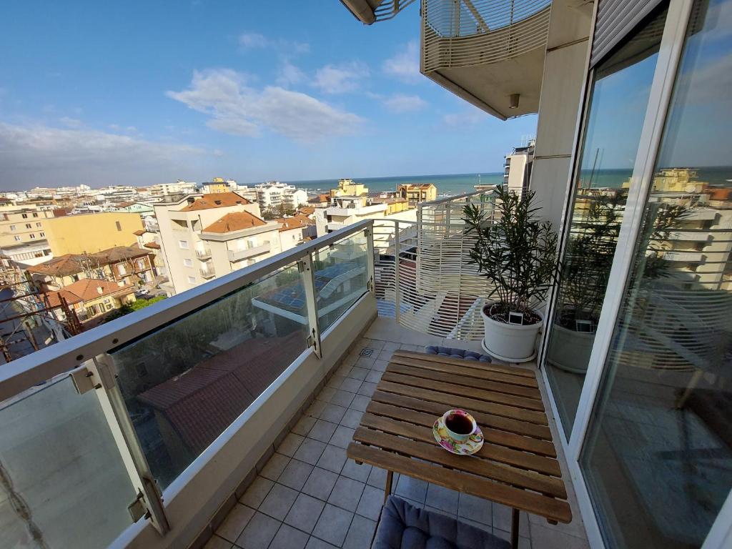 een balkon met een houten bank en uitzicht op de stad bij Anastasia's boutique apartment in Cattolica