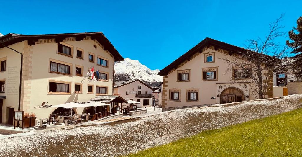 a group of buildings with mountains in the background at Albana Hotel Silvaplana in Silvaplana