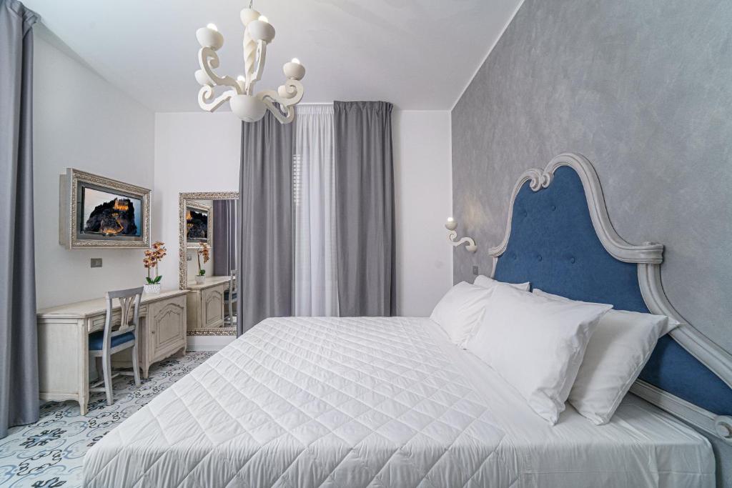 A bed or beds in a room at PLAZA Boutique Hotel - Tropea