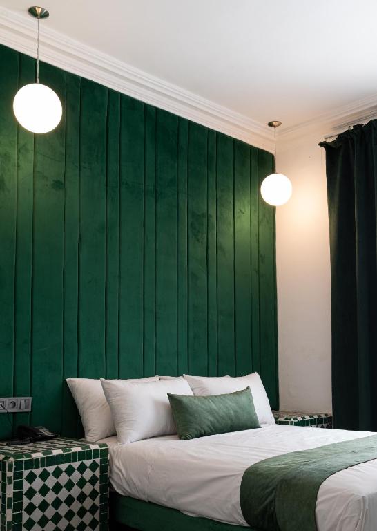 a bedroom with a green wall and a bed at Hotel Majestic in Casablanca